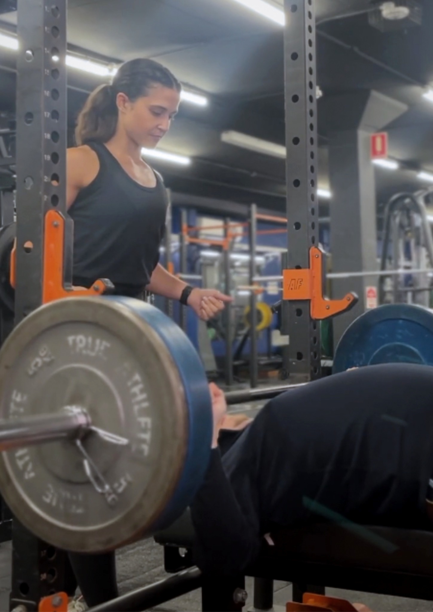 Samantha spotting John during a bench press session