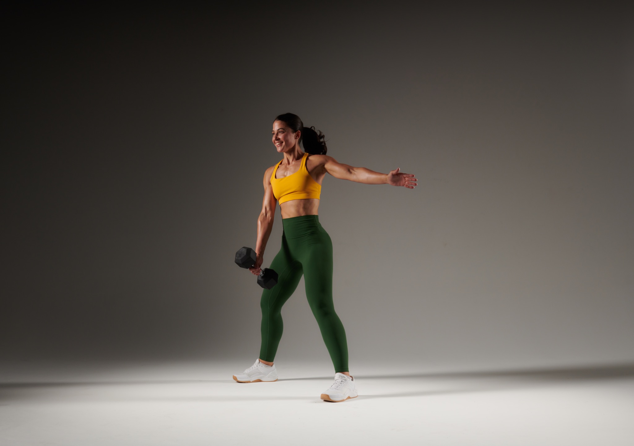 Samantha Lourens holding a dumbbell in a studio strength portrait